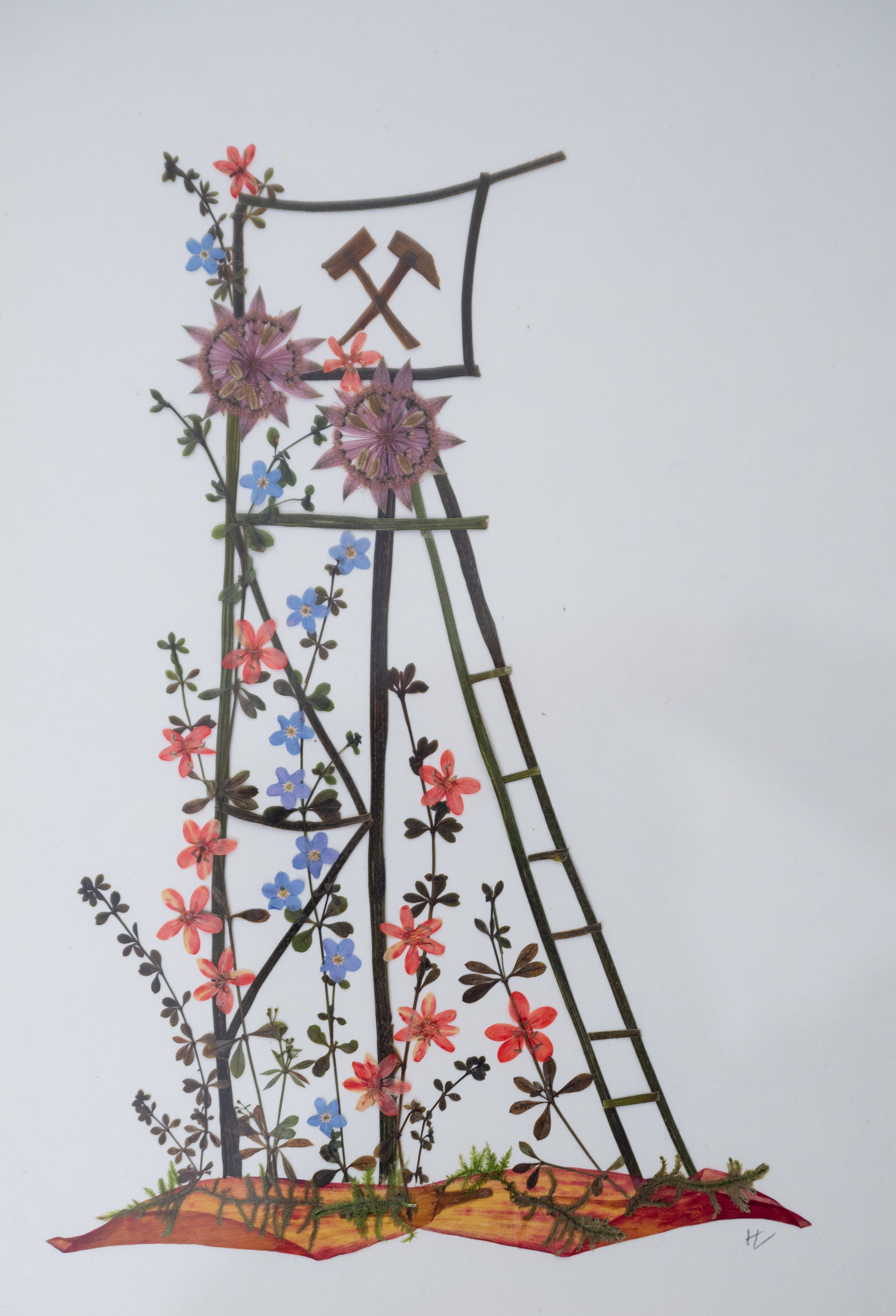 Darstellung des Förderturms der Zinngrube Ehrenfriedersdorf (hoher Turm aus Metallgerüst mit Förderrädern) mithilfe von verschiedenfarbigen und großen Blüten und -anderen Pflanzenteilen (Stängel, Blätter). 